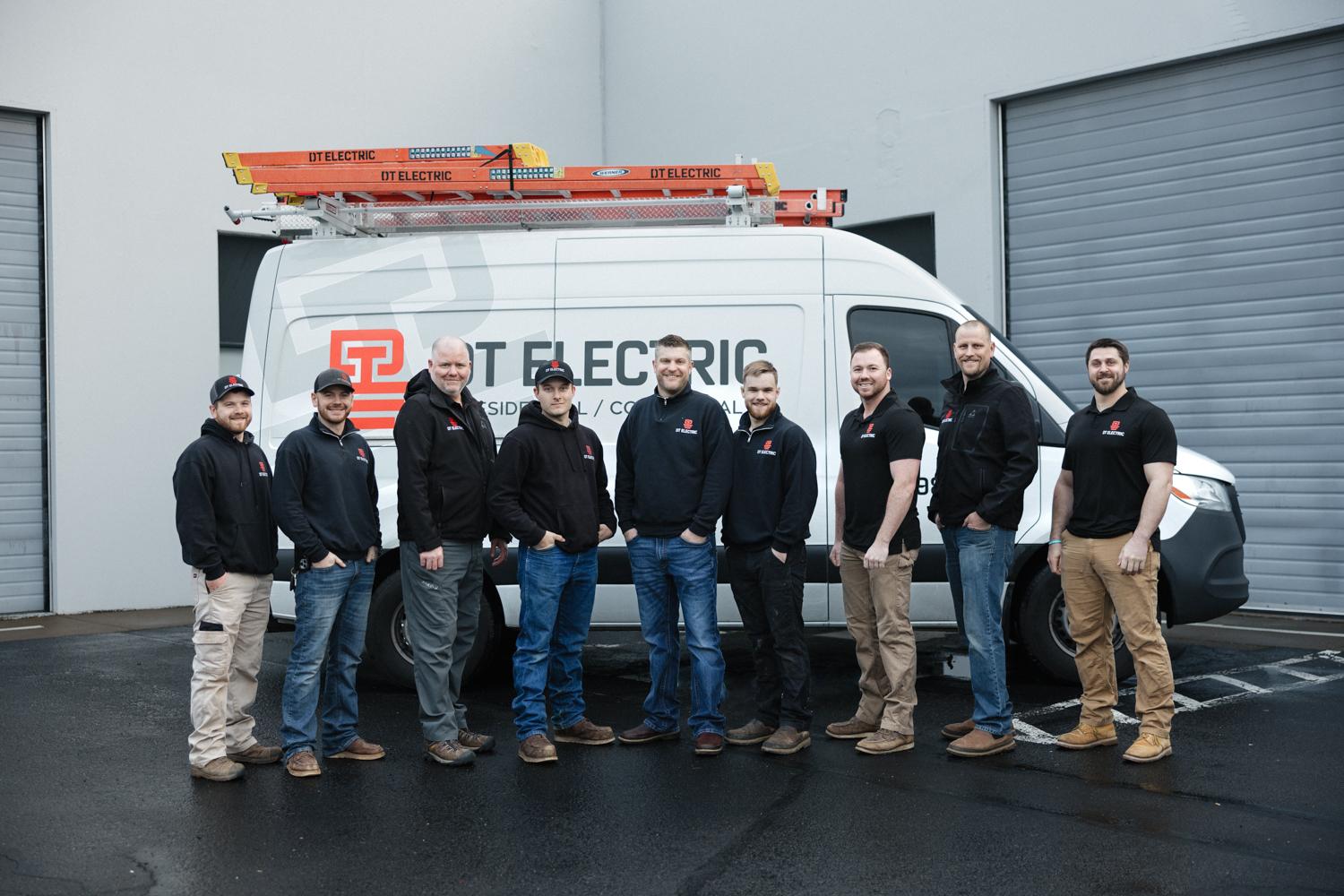 DT Electric electricians standing in front of a service truck